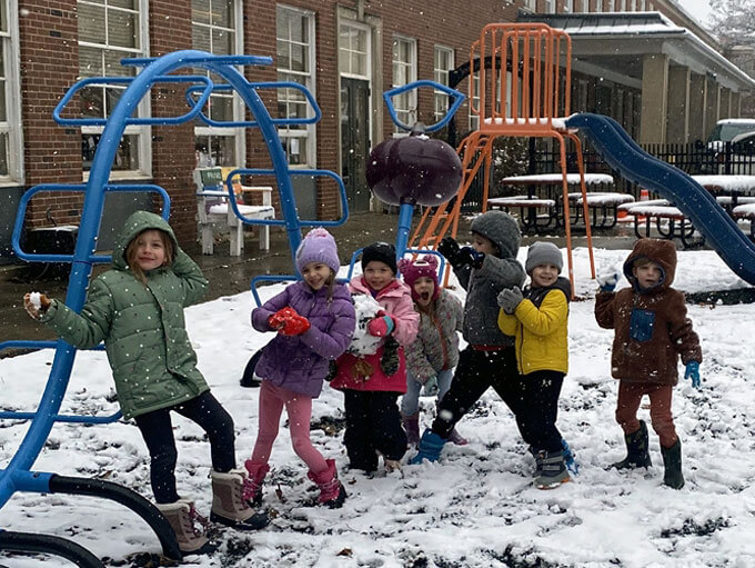 Seven students play in the snow.