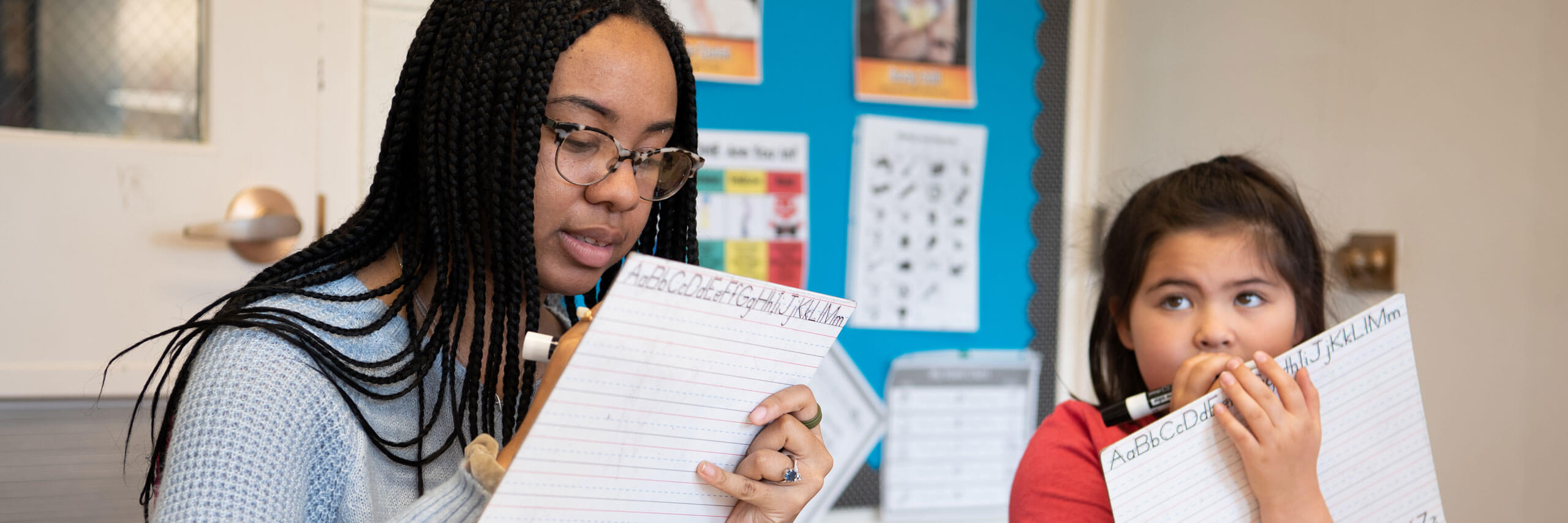 A student teacher helps a student with an assignment.